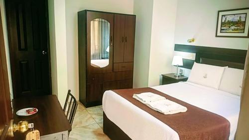 a bedroom with a bed and a table and a door at Samay Misti Hostal in Arequipa