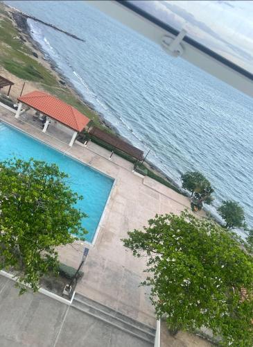 einen Blick über einen großen Pool neben dem Wasser in der Unterkunft Spacious two bedrooms with sea and city view in Portmore