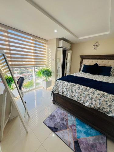 ein Schlafzimmer mit einem Bett und einem großen Fenster in der Unterkunft Spacious two bedrooms with sea and city view in Portmore