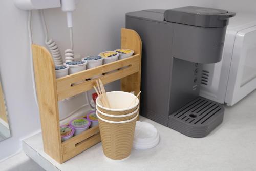 a coffee machine with cups on a shelf next to a coffee maker at Stay Inn Muskoka in Gravenhurst