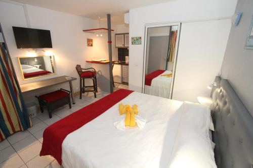 a bedroom with a bed with a teddy bear on it at Hotel La Maison Creole in Le Gosier