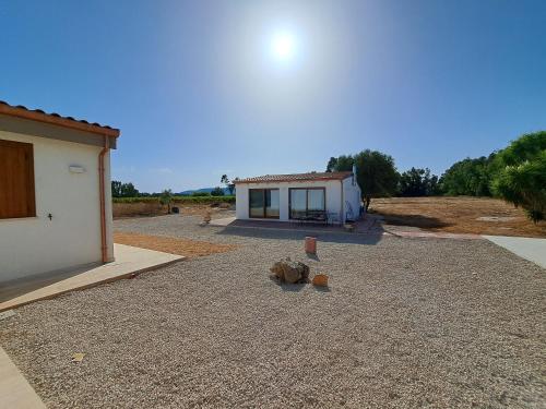 a house with a gravel yard next to a building at Country house pura natura Alghero in Casa Minnina