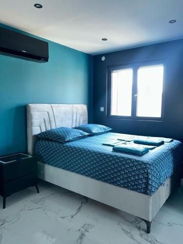 ein Schlafzimmer mit einem Bett mit blauen Wänden und einem Fenster in der Unterkunft Love Room Paradise in Saint-Genest-Lerpt