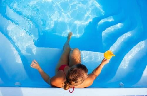 a woman is playing with a rubber duck in a pool at Hundi Holiday Home Main House in Hiiumaa