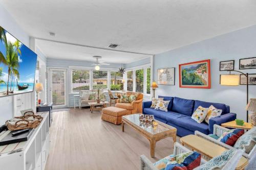 a living room with a blue couch and a table at Bromeliad Bungalow - Downtown Cottage in Fort Lauderdale