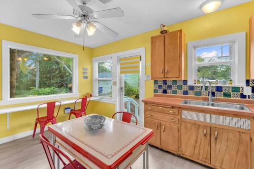 a kitchen with yellow walls and a table and chairs at Bromeliad Bungalow - Downtown Cottage in Fort Lauderdale