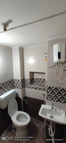 a bathroom with a white toilet and a sink at Shree chendur Residency in Tiruvannāmalai
