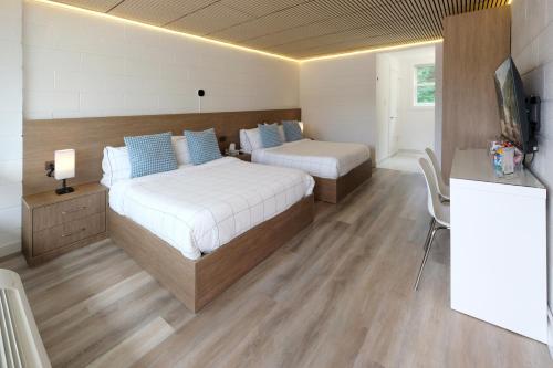a bedroom with two beds and a television in it at Stay Inn Muskoka in Gravenhurst