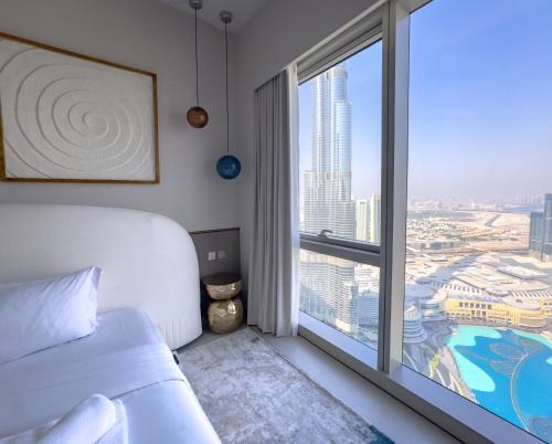 a bedroom with a bed and a large window at GRANDE RESIDENCES with a direct Burj Khalifa view and Private Fountain Show at 62nd floor with DXB AIRPORT VIP Shuttle for 6 guests in Dubai