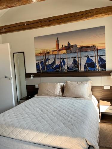a bedroom with a bed with a painting on the wall at Casa sulla Laguna CASTELLO in Venice