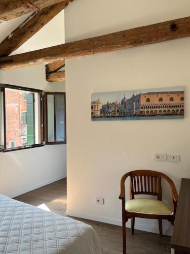 a bedroom with a bed and a chair in a room at Casa sulla Laguna CASTELLO in Venice