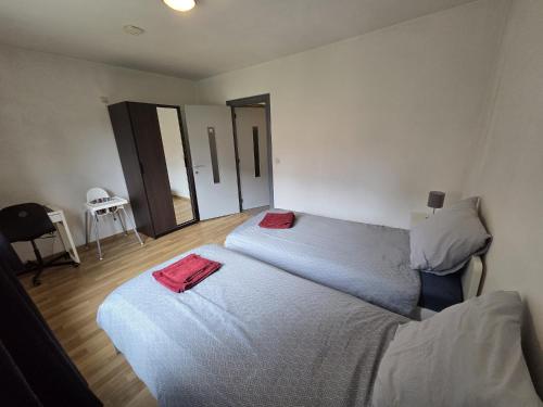une chambre avec deux lits avec des serviettes rouges dessus dans l'établissement Bel-étage cosy 2 chambres proche Charleroi-Airport, à Charleroi