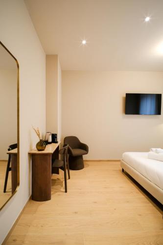 una camera da letto con un letto, una scrivania e una televisione di Balcony Studio Double Suite - Bernina Experience a Tirano