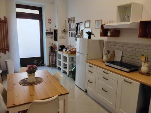 a kitchen with a table and a white refrigerator at LA MURGIA casa vacanze B&B in Grumo Appula