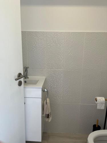 a bathroom with a sink and a toilet at Beach house Estrela do Mar in Vila Chã
