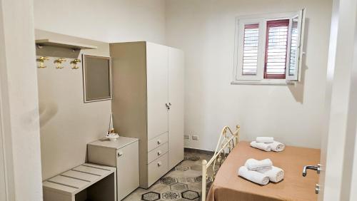 a small room with a table and a bed and a window at Jasmine House Ustica heart in Ustica