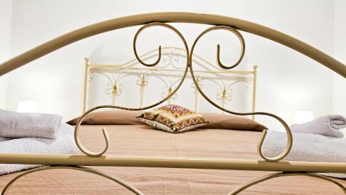 a bed with a metal frame with a pillow on it at Jasmine House Ustica heart in Ustica