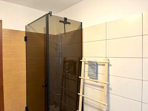 a shower in a bathroom with a glass wall at Panorama Pine Retreat - Spacious 2-Bedroom Flat in Predeal