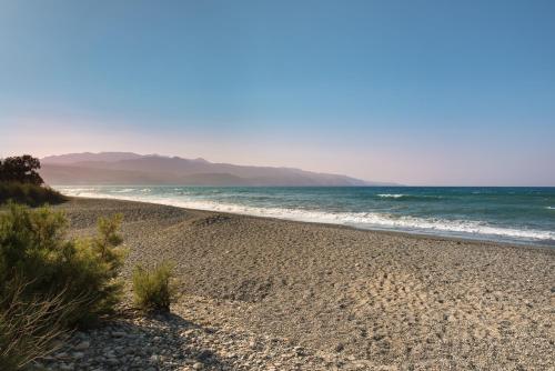 a sandy beach with the ocean in the background at Sirens House in Tavronitis