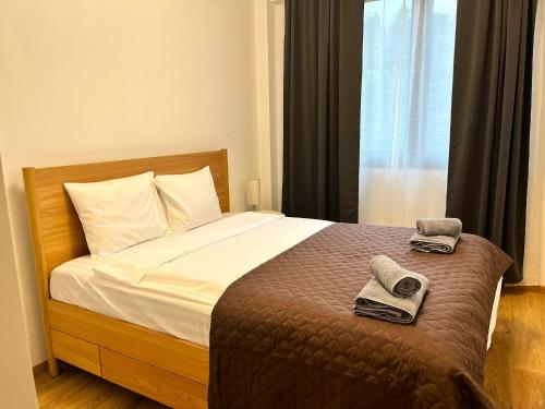 a bedroom with a bed with towels and a window at Panorama Pine Retreat - Spacious 2-Bedroom Flat in Predeal