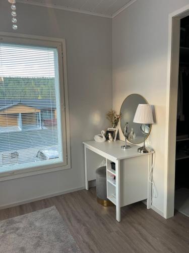 a white desk with a lamp and a mirror at Villa Mustikka 