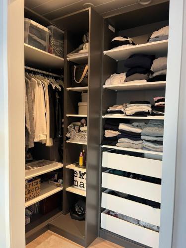 a walk in closet with white shelves at Villa Mustikka 