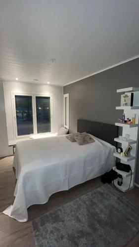 a bedroom with a large white bed and two windows at Villa Mustikka 