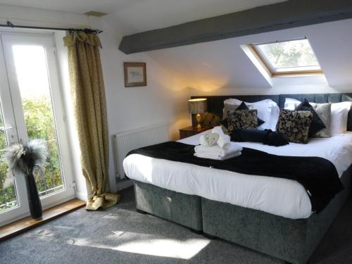 une chambre avec un grand lit et une fenêtre dans l'établissement The Shakespeare Lodge - Sleeps up to 12 - 2 HOT TUBS, à Stratford-upon-Avon