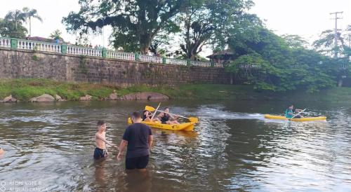 a group of people in a river with boats at Casa Dona Flor in Morretes