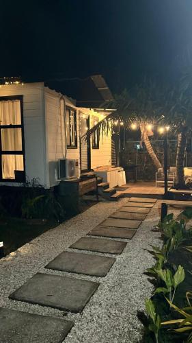 a house at night with a pathway leading to it at 2 bedroom Guest House with comp ride to the airport in Ladyville