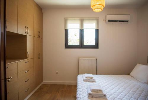 a small bedroom with a bed and a window at Aegina Horizon Stonehouse No I in Aegina