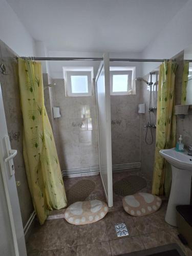 a bathroom with a shower with yellow shower curtains at Rodica Apartment in Sibiu