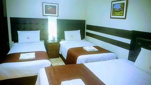 a hotel room with two beds and a table at Samay Misti Hostal in Arequipa