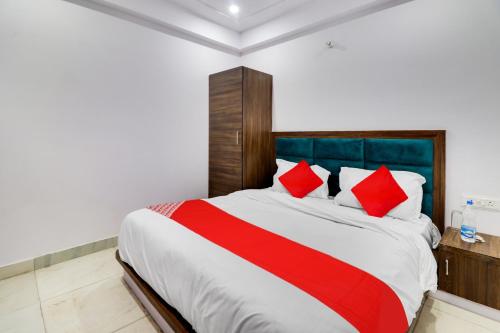 a bedroom with a large bed with red pillows at Hotel O ANNU RESIDENCY in Alīgarh