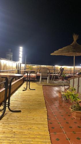 a boardwalk with tables and chairs and an umbrella at Downtown Hostel in Fès