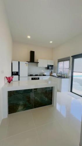 a large white kitchen with a large counter top at Vela Pool Villa Hatyai in Sathani Khlong Rian