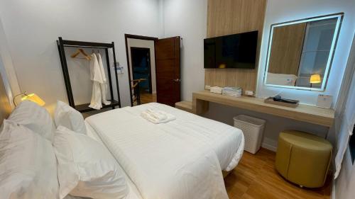 a bedroom with a white bed and a window at Queen Ma Pool villa in Ban Nong Bua