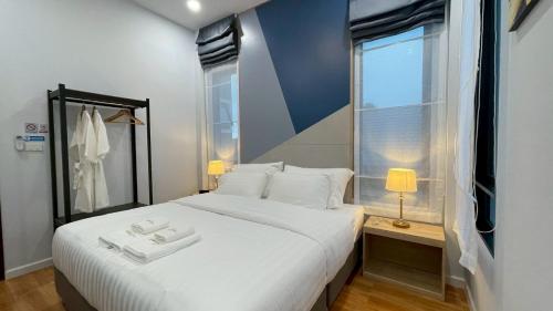 a bedroom with a large white bed and a window at Queen Ma Pool villa in Ban Nong Bua