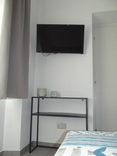 a bedroom with a bed and a flat screen tv on the wall at BnB Ranco in Ranco
