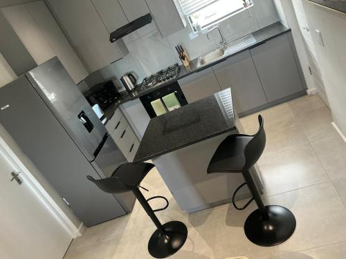 a kitchen with a counter and two stools in a kitchen at DRJ Luxe Table view in Table View