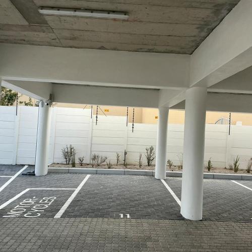 an empty parking lot with columns and a white wall at DRJ Luxe Table view in Table View