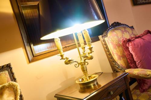 a lamp sitting on a table next to a chair at Albergo Trattoria Il Leone in Pomponesco