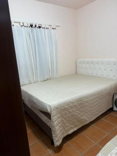 Bett in einem Zimmer neben einem Fenster in der Unterkunft APT PERÓ Livio Viviani in Cabo Frio