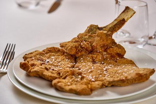 a white plate with some food on a table at Albergo Trattoria Il Leone in Pomponesco