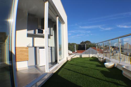 a balcony of a house with a yard of grass at Bike Suite in Figueira da Foz
