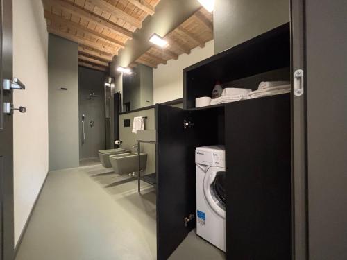 a bathroom with a washer and dryer in a room at Appartamenti Saragozza a due passi da Piazza Grande - WIFI e parcheggio gratuito in Modena