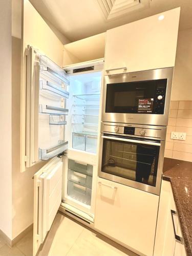an open refrigerator with its door open in a kitchen at Al Mouj Marina Apartment with Pool & Beach Access in Ḩayl Āl ‘Umayr