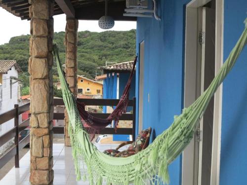 a hammock on the balcony of a house at Pousada Pipa Pé na Areia in Pipa