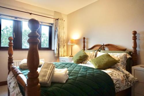a bedroom with a bed with a green comforter at The Peak View - Holmfirth in Cartworth