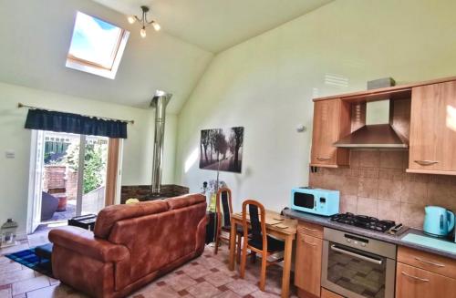 a kitchen with a couch and a table with a microwave at Birch Cottage in Aviemore